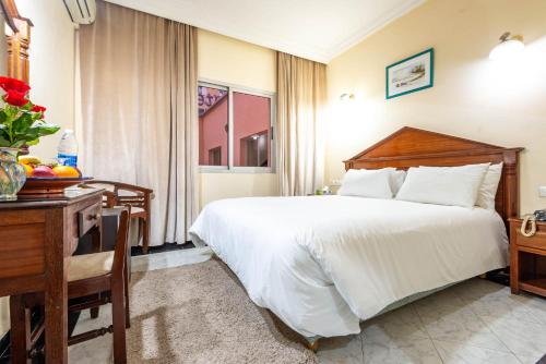a hotel room with a bed and a desk and a bed sidx sidx at Hotel Oudaya & Spa in Marrakech