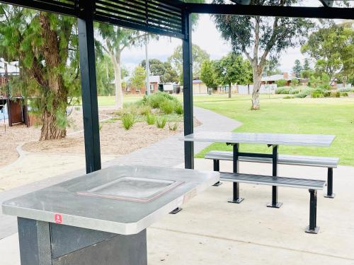 a ping pong table and benches in a park at Beautiful pradise in Smithfield