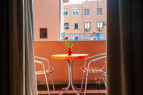 a table with a vase with a flower on it next to a window at Hotel Oudaya & Spa in Marrakech