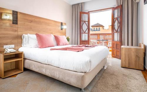 a bedroom with a large bed and a balcony at Hotel Oudaya & Spa in Marrakech