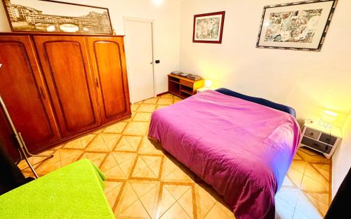 a bedroom with a purple bed and a cabinet at La casa dell’artista di Vittorio Vertone in Pietragalla