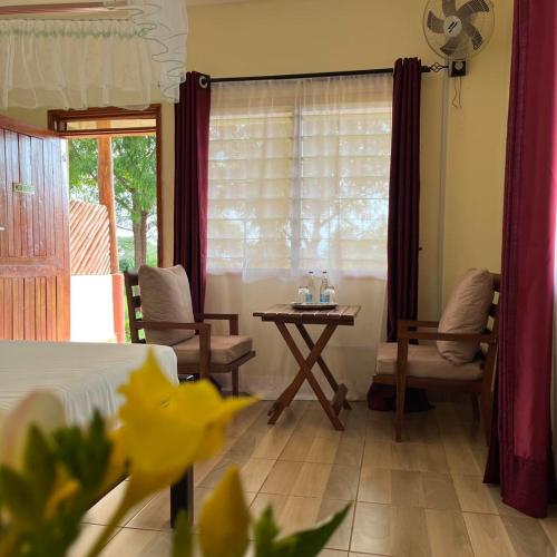 a bedroom with a bed and a table with a table at Lake Jipe Eco Lodge in Tsavo West National Park