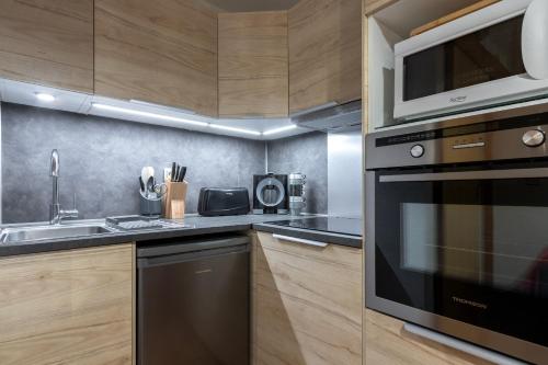 une cuisine avec une cuisinière et un micro-ondes dans l'établissement Jardin du Mont Blanc, à Chamonix-Mont-Blanc