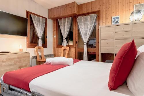 une chambre avec un grand lit blanc avec des oreillers rouges dans l'établissement Jardin du Mont Blanc, à Chamonix-Mont-Blanc