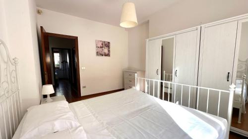 a white bedroom with two beds and a closet at N194 - Numana, ampio trilocale con giardino in Numana