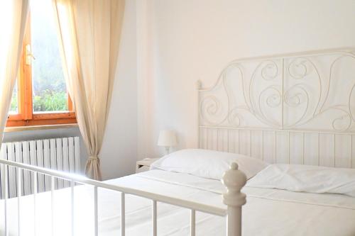 a bedroom with a white bed and a window at N194 - Numana, ampio trilocale con giardino in Numana