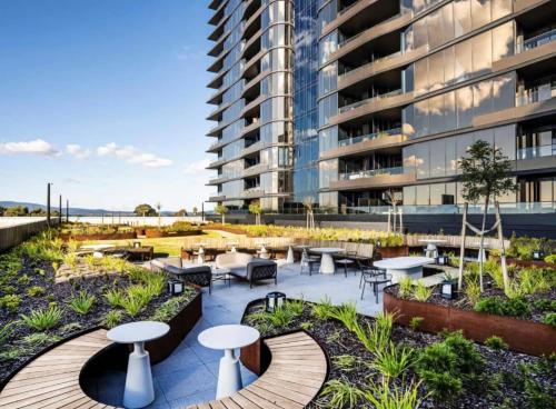 an outdoor patio with tables and chairs and a building at Heart of Glen Waverley Pool Gym Parking in Glen Waverley