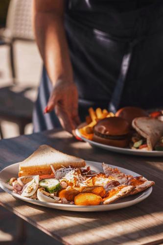 a person standing in front of two plates of food at Leonardo Cypria Bay in Paphos City