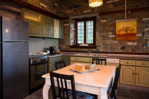 a kitchen with a table and a refrigerator at Venieri's Stone Villa in Tsagarada