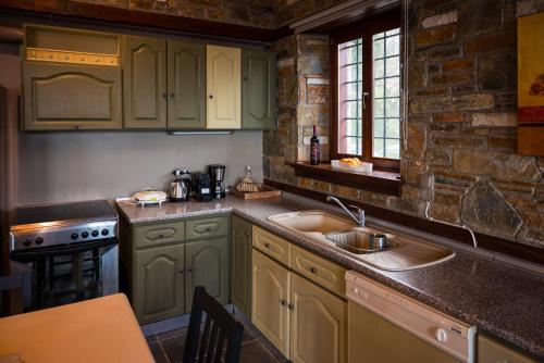 a kitchen with green cabinets and a sink at Venieri's Stone Villa in Tsagarada