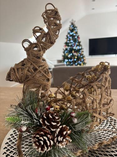 a reindeer ornament on a table with a christmas tree at 1 Old Sefter School House in Bognor Regis