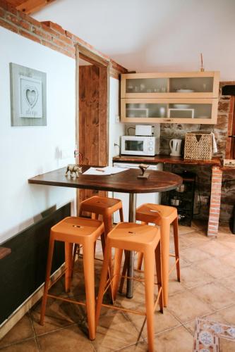 a kitchen with a table and stools in a room at Carbayu Senda del Oso in Proaza