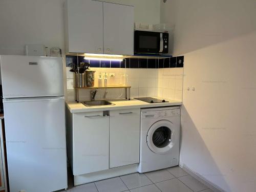 Il comprend une cuisine équipée d'un réfrigérateur blanc et d'un lave-linge. dans l'établissement NP045-017 Appartement 2 pièces, 1 chambre, Narbonne Plage, à Narbonne-Plage