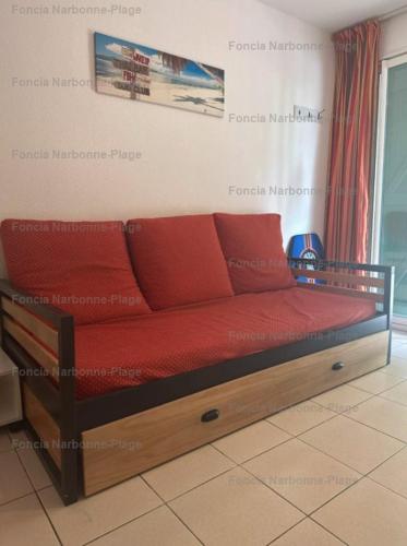 - un lit avec des oreillers rouges dans l'établissement NP045-017 Appartement 2 pièces, 1 chambre, Narbonne Plage, à Narbonne-Plage