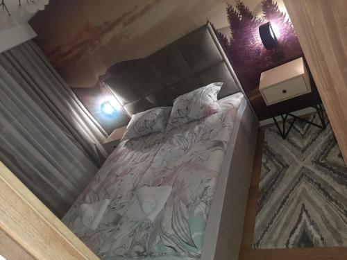a small bedroom with a bed with a headboard at Jahorina Apartman in Pale