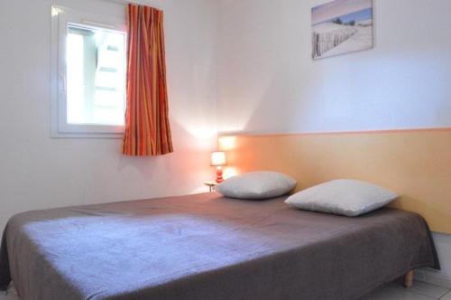 - un lit avec 2 oreillers dans une chambre dans l'établissement NP045-018 Appartement 2 pièces, Narbonne Plage, à Narbonne-Plage