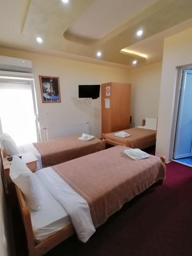a hotel room with two beds and a television at Hotel Talija in Svilajnac