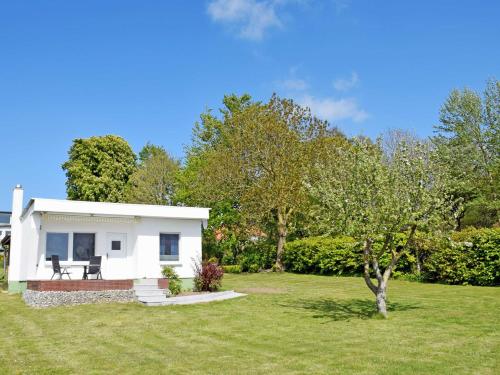 a small white house in a grassy yard at Bungalow Sundblick in Altefähr