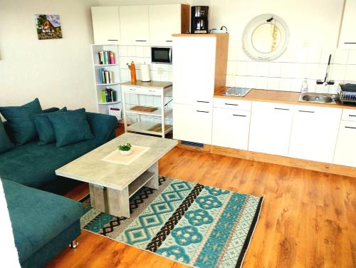 a living room with a couch and a table and a kitchen at Bungalow Sundblick in Altefähr