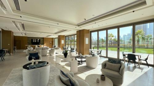 a lobby with white chairs and tables and windows at Dubai Mall Connected! AMAZING Burj Khalifa View! Excellent Pool & Gym Access! in Dubai