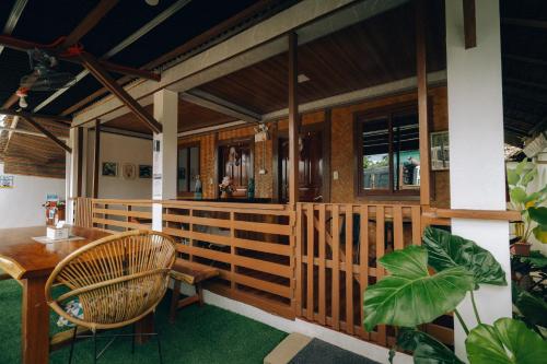 a porch of a house with a table and chairs at Nay Carmen Pension House Port Barton in Itaytay