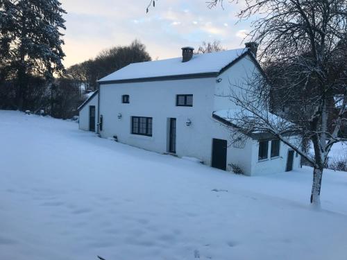 a white house in the snow at La Petite Maison Blanche in Wanze