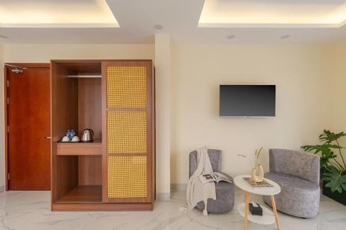 a living room with a chair and a tv at Thé Villa in Da Lat