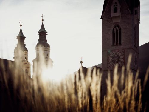 a church with a clock tower in the background at ADLER Historic Guesthouse in Bressanone