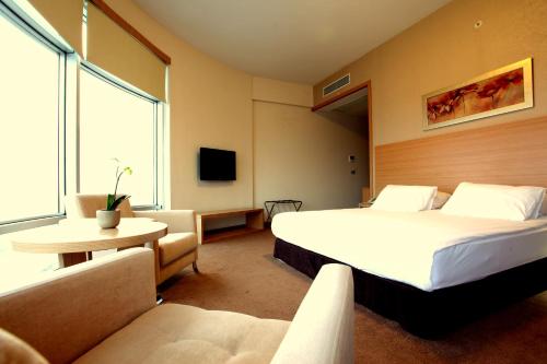 a hotel room with two beds and a couch at Orucoglu Oreko Hotel in Manisa