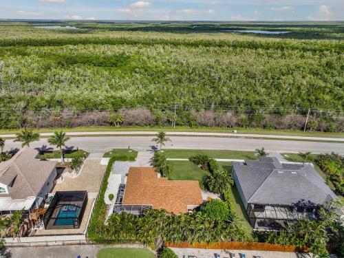 an aerial view of a house with a field of trees at Quiet inland home with pool, two queen beds and grill in Marco Island