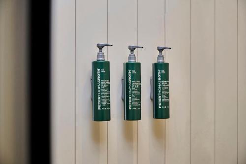 three green toothbrushes are hanging on a wall at Hilton Garden Inn Foshan Lishui-Free Shuttle Bus for Canton Fair in Foshan