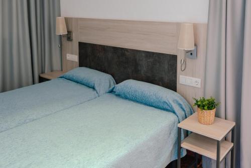 a bedroom with two beds with blue pillows at Port Europa in Calpe