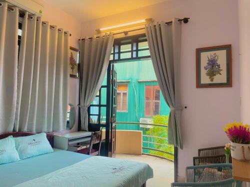 a bedroom with a bed and a large window at Nhà Bơ Homestay in Thôn Kim Long (1)