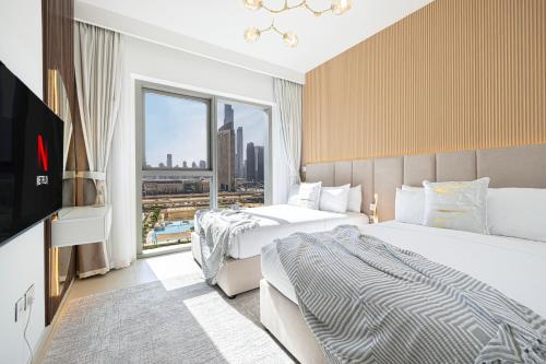 a hotel room with two beds and a flat screen tv at Dubai Mall Connected! AMAZING Burj Khalifa View! Excellent Pool & Gym Access! in Dubai