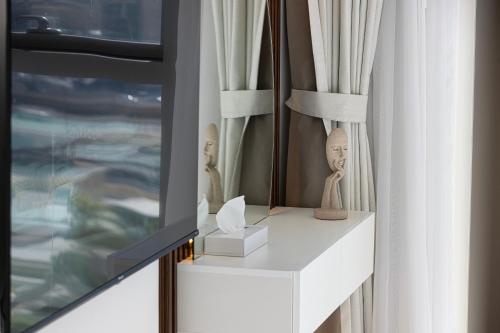 a living room with a tv and a white dresser at Dubai Mall Connected! AMAZING Burj Khalifa View! Excellent Pool & Gym Access! in Dubai