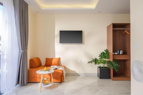 a room with a bed and a table and a tv at Thé Villa in Da Lat