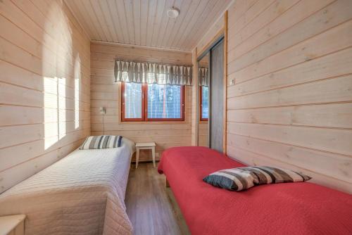 a bedroom with two beds in a wooden cabin at Holiday Apartments Kruunurinne 1 & 2 in Himos
