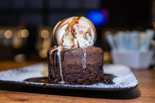 a chocolate cake with ice cream on a plate at Aster Hotel in Jeddah