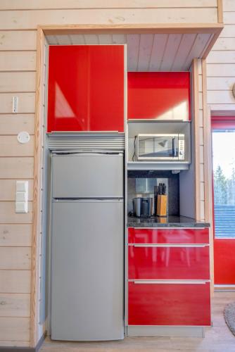 a kitchen with a refrigerator and a microwave at Holiday Apartments Kruunurinne 1 & 2 in Himos