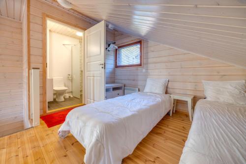 a bedroom with two beds and a bathroom at Holiday Apartments Kruunurinne 1 & 2 in Himos