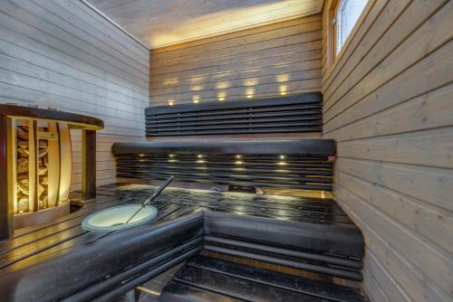 a sauna with a tub in a wooden building at Holiday Apartments Kruunurinne 1 & 2 in Himos