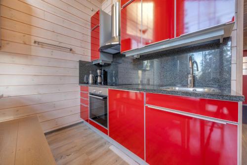 a kitchen with red cabinets and a sink at Holiday Apartments Kruunurinne 1 & 2 in Himos