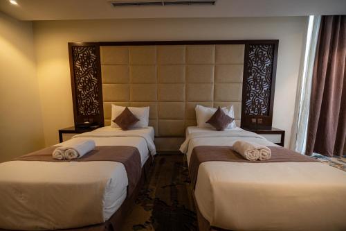 two beds in a hotel room with towels on them at Aster Hotel in Jeddah