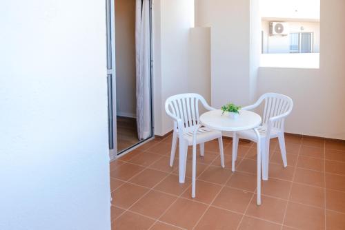 two white chairs and a table in a room at Port Europa in Calpe