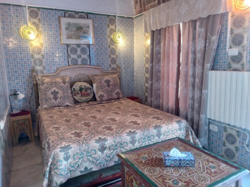 a bedroom with a bed with a box on a table at Hôtel Bou Fares in Sidi Bou Saïd