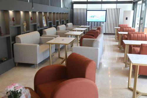 a restaurant with tables and chairs and a screen at Del Mare Park in Kérynia