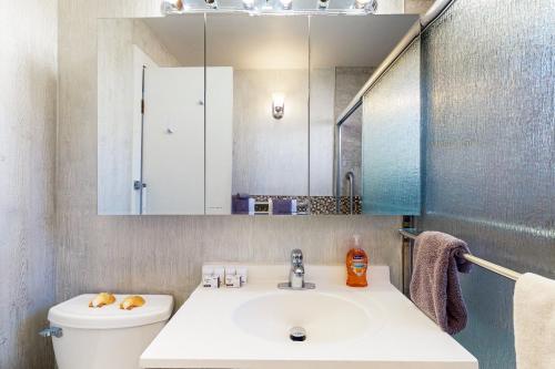 ein Badezimmer mit Waschbecken, Toilette und Spiegel in der Unterkunft Gray Goose Beach Cottage in Coos Bay