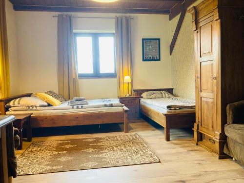a bedroom with two beds and a window at Modryna - Modrzewiowy Dom in Cisna