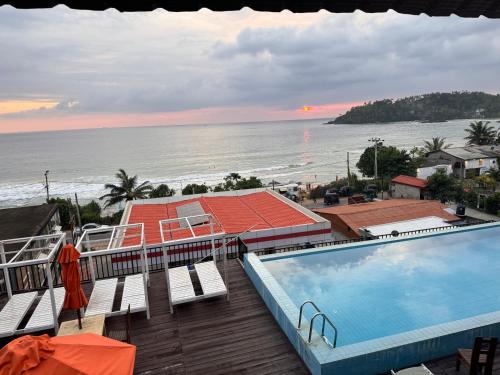 a view of a swimming pool and the ocean at One World Mirissa in Mirissa