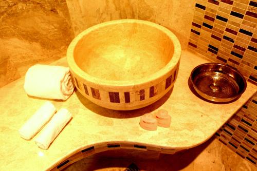 a bathroom with a large wooden bowl on a sink at Orucoglu Oreko Hotel in Manisa